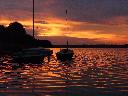 wschód słońca nad jeziorem powidzkim i jacht żaglowy