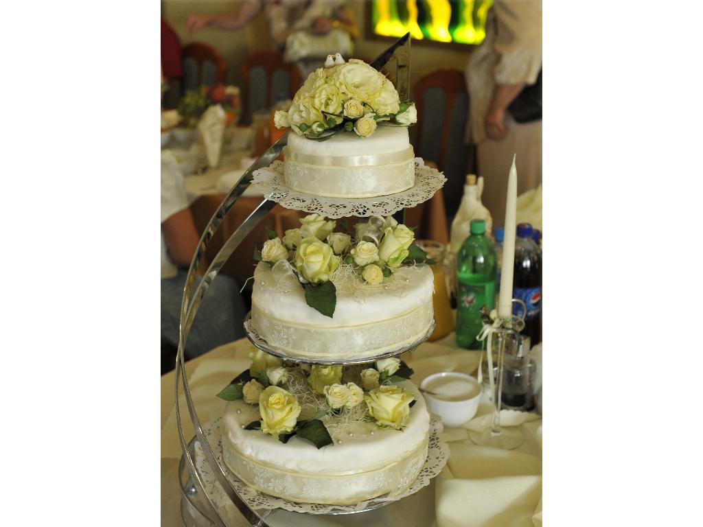 Tort piętrowy weselny z masy cukrowej ozdobiony żywymi kwiatami