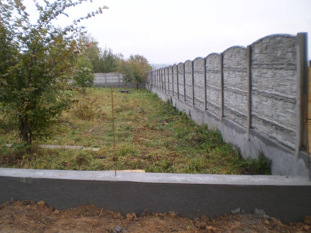 ogrodzenie z betonowych płyt na fundamencie i podmurówce