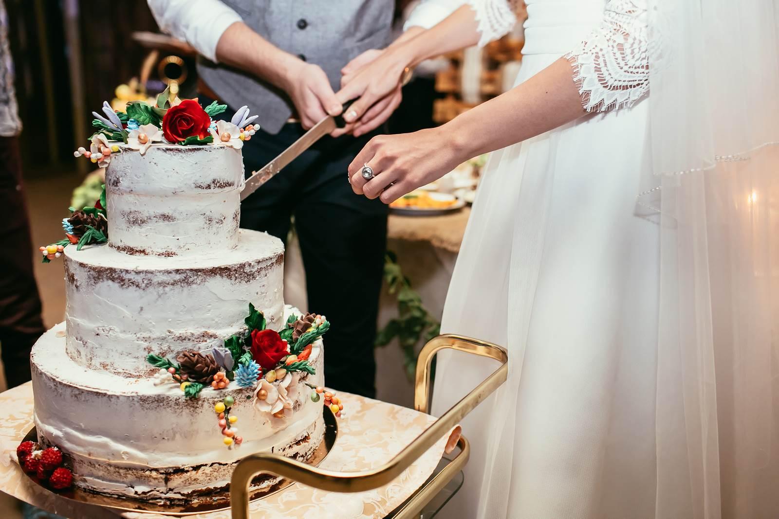 Państwo Młodzi kroją ślubny tort na weselu